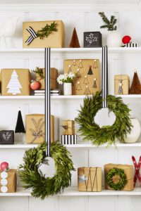 Too many gifts under the tree — or no tree at all? Use a bookshelf! To unify the look, wrap with kraft paper and add black, white and silver accents. What you'll need: kraft paper ($18, amazon.com), striped ribbon ($14, amazon.com)