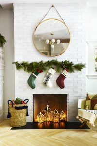 Use a washable-paint marker to add fluttery flakes to a mirror. Festive stockings — attached to a faux garland — and a tassel basket hold plenty of goodies. What you'll need: paint pen ($9, amazon.com), pine garland ($20, target.com), stockings ($13 each, target.com), basket ($98, crateandbarrel.com)